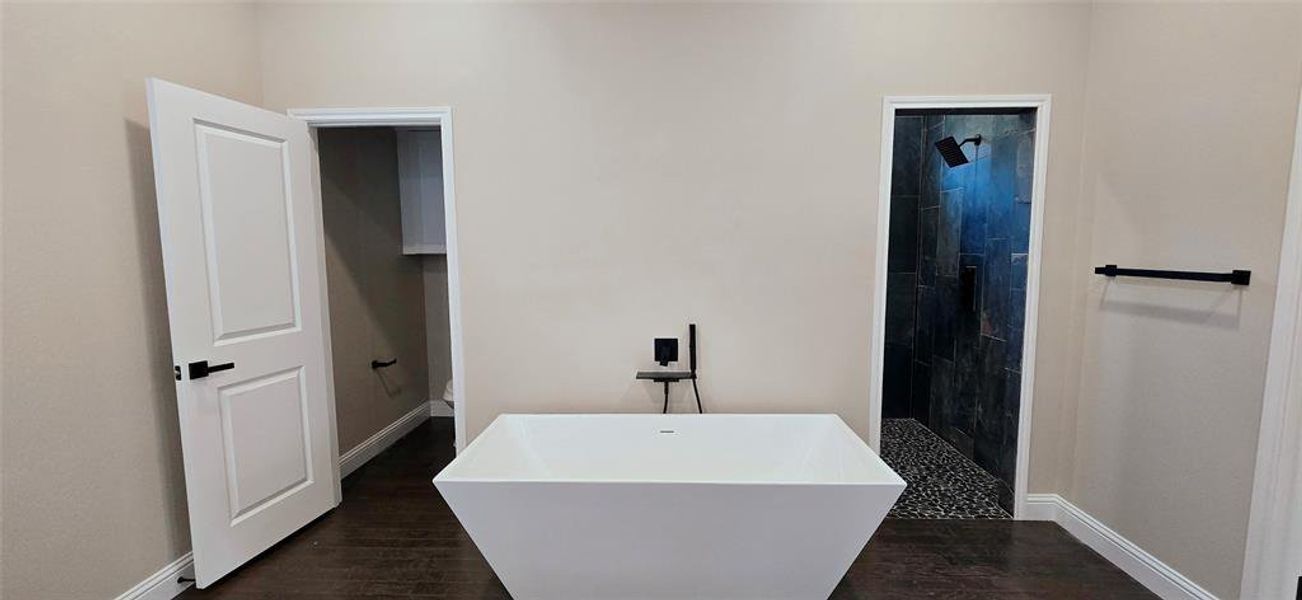 Full bathroom featuring a soaking tub, shower, and dark wood finished floors Full bathroom featuring a soaking tub, shower, and dark wood finished floors