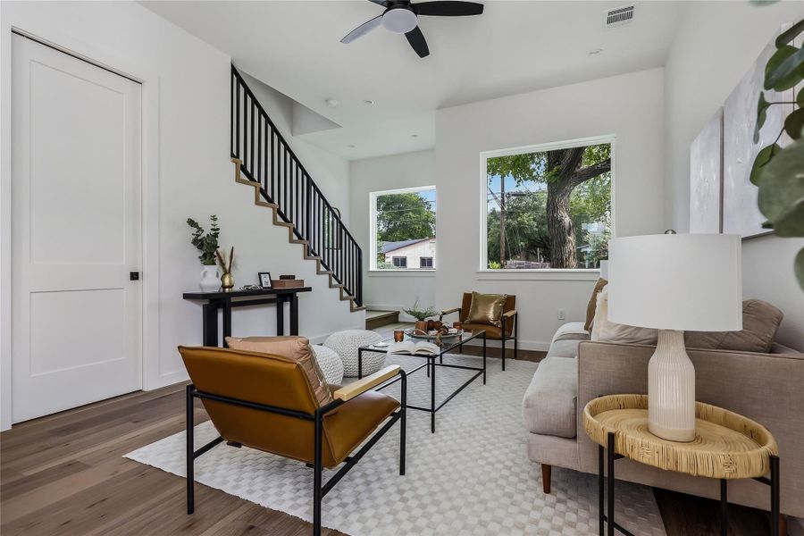 A contemporary living area with engineered hardwood floors and a modern staircase creates an inviting atmosphere.
