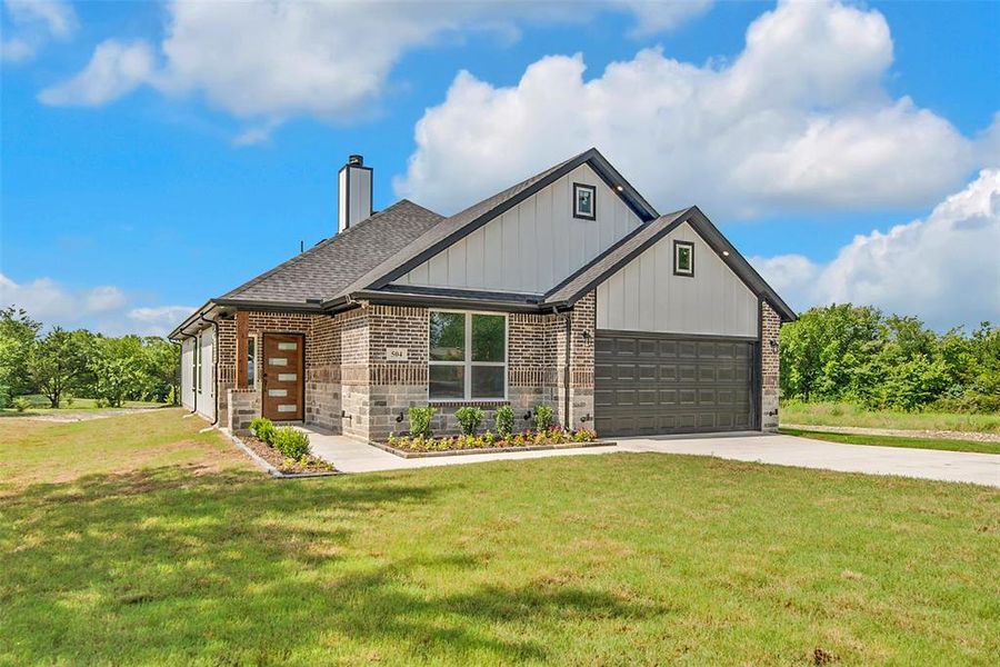View of front of home featuring driveway, a chimney, a front lawn, a shingled roof, and an attached garage View of front of home featuring driveway, a chimney, a front lawn, a shingled roof, and an attached garage