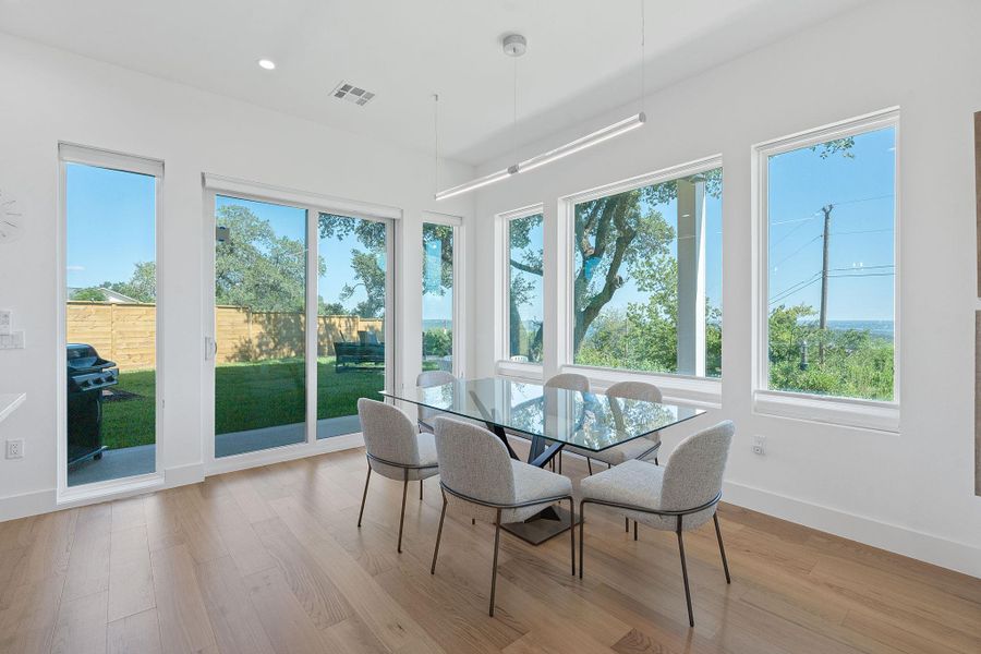 A dining space wrapped in windows, Hill Country and Lake Travis views great for family nights and entertaining. A dining space wrapped in windows, Hill Country and Lake Travis views great for family nights and entertaining.