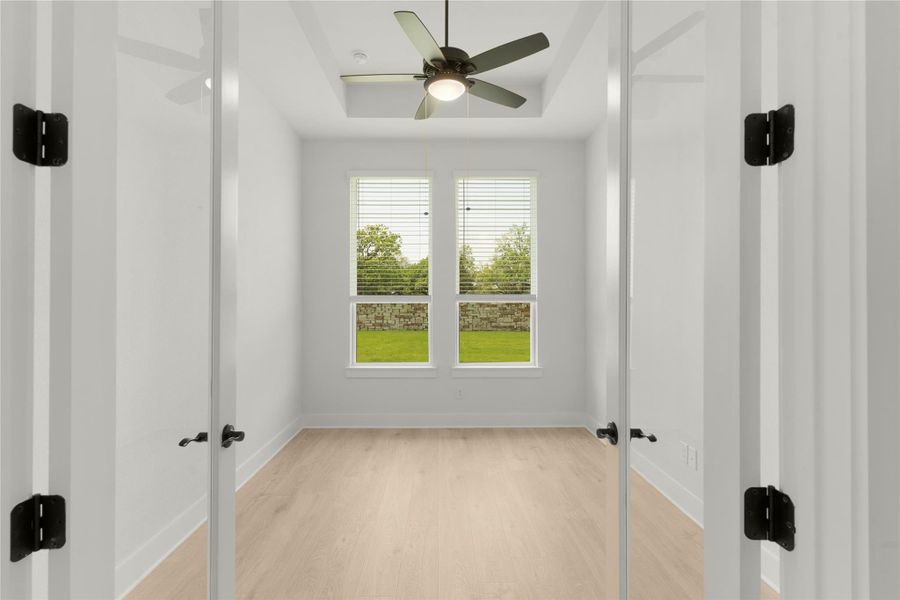 Unfurnished bedroom featuring light wood-style floors and a raised ceiling Unfurnished bedroom featuring light wood-style floors and a raised ceiling