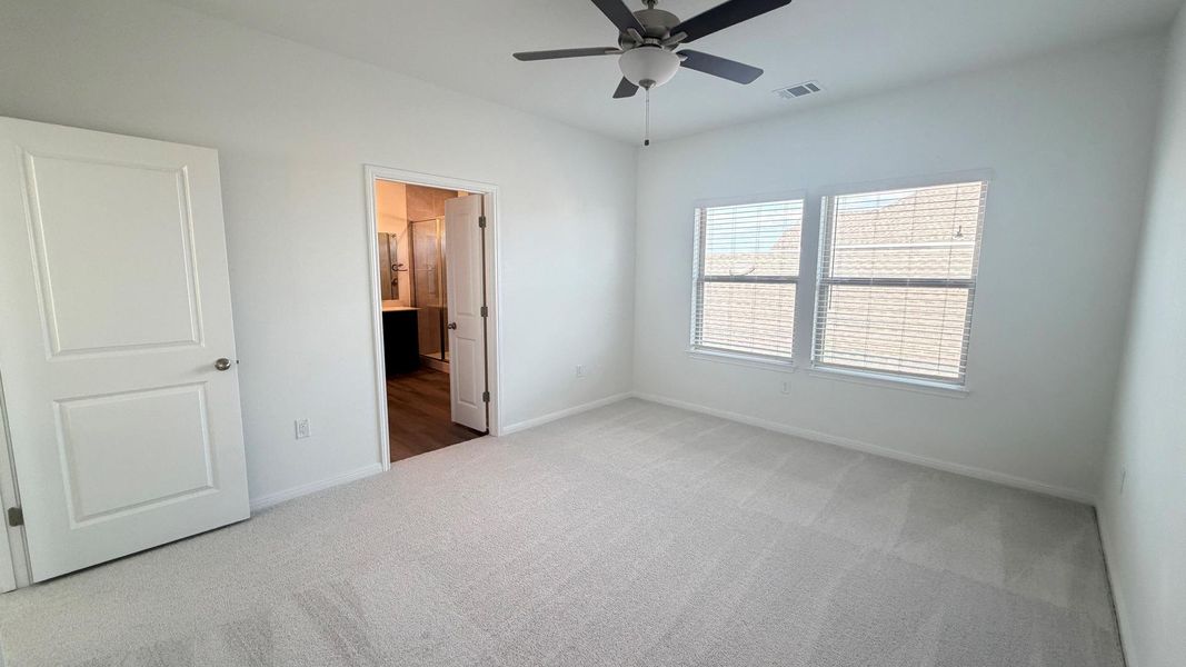 A quiet bedroom retreat with a ceiling fan, plush carpeting, and private bathroom access awaits. A quiet bedroom retreat with a ceiling fan, plush carpeting, and private bathroom access awaits.