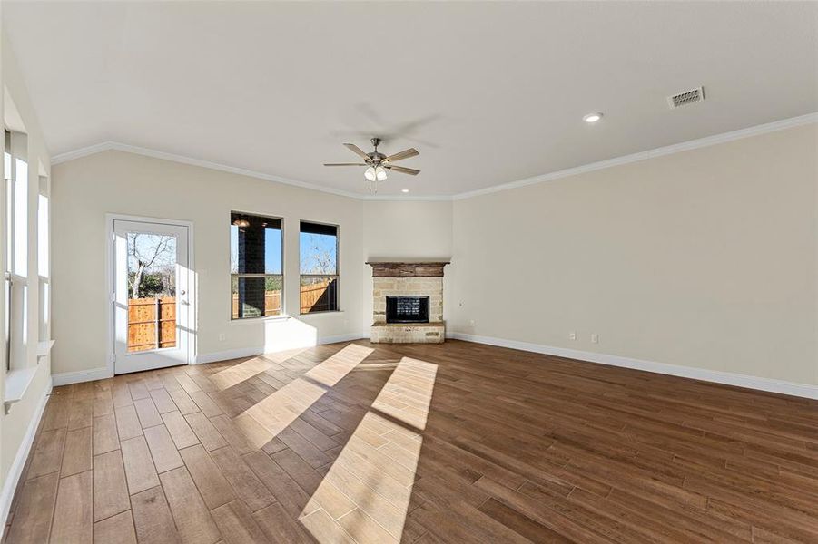 Unfurnished living room with crown molding, a fireplace, and ceiling fan