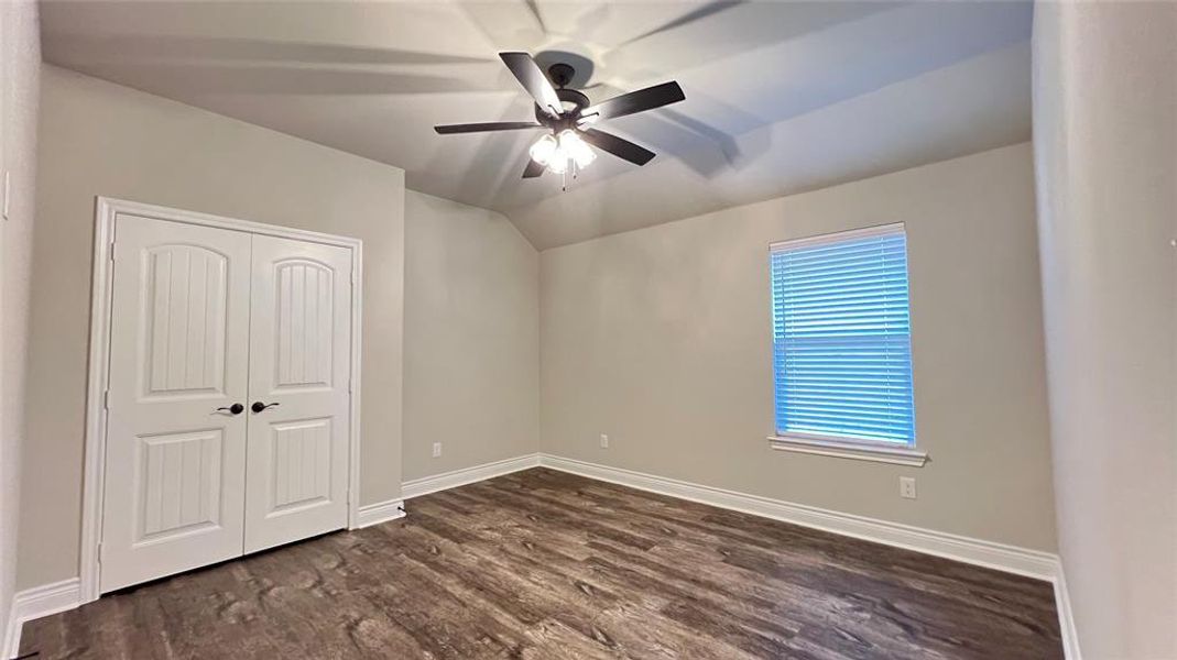 Unfurnished bedroom featuring dark hardwood / wood-style floors, a closet, and ceiling fan