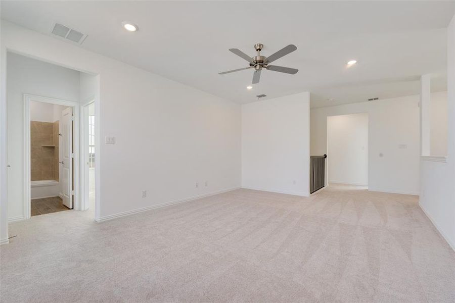 Carpeted empty room featuring ceiling fan