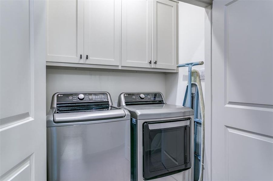 Laundry Closet With Double Doors and Cabinets