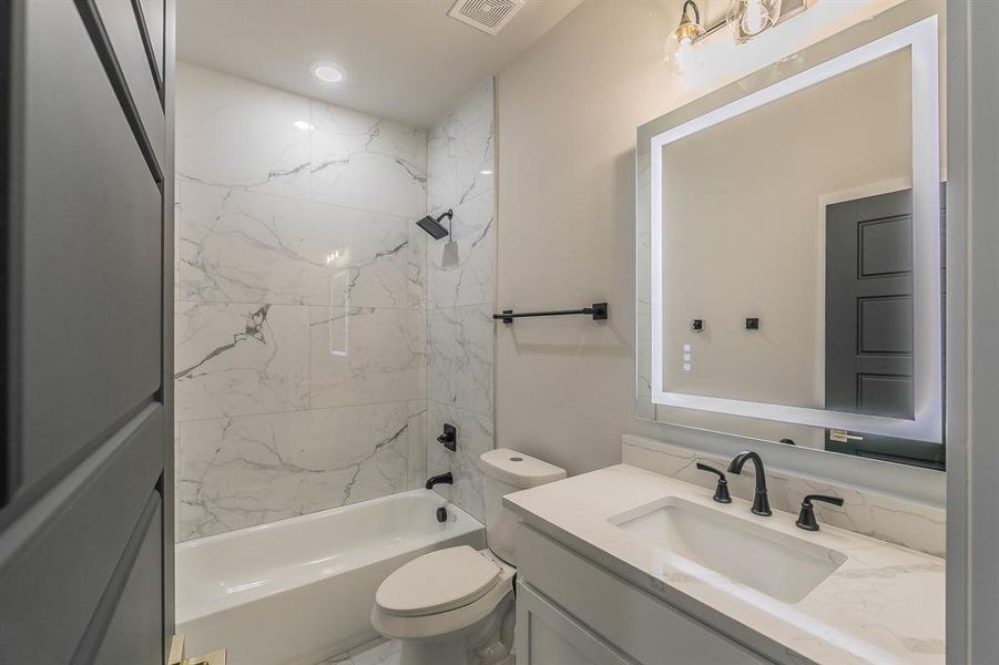 Full bathroom with vanity, toilet, and tiled shower / bath