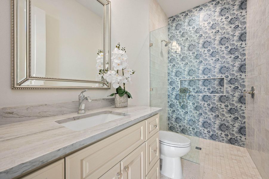 Full bath with vanity, a shower stall, and light tile patterned flooring