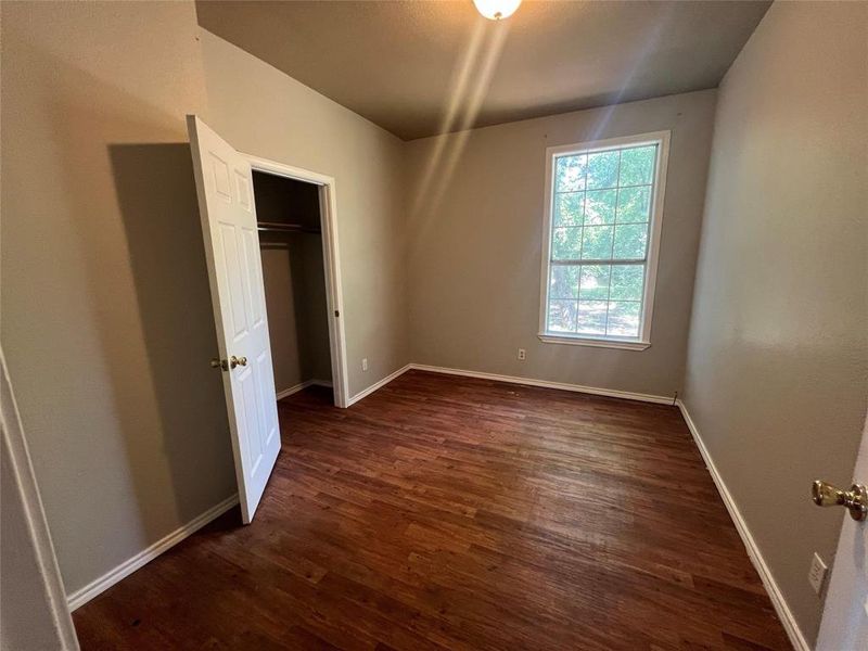 Unfurnished bedroom featuring baseboards and dark wood finished floors Unfurnished bedroom featuring baseboards and dark wood finished floors