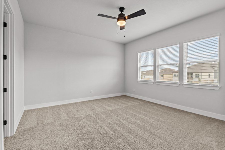 A room with a ceiling fan and a window.