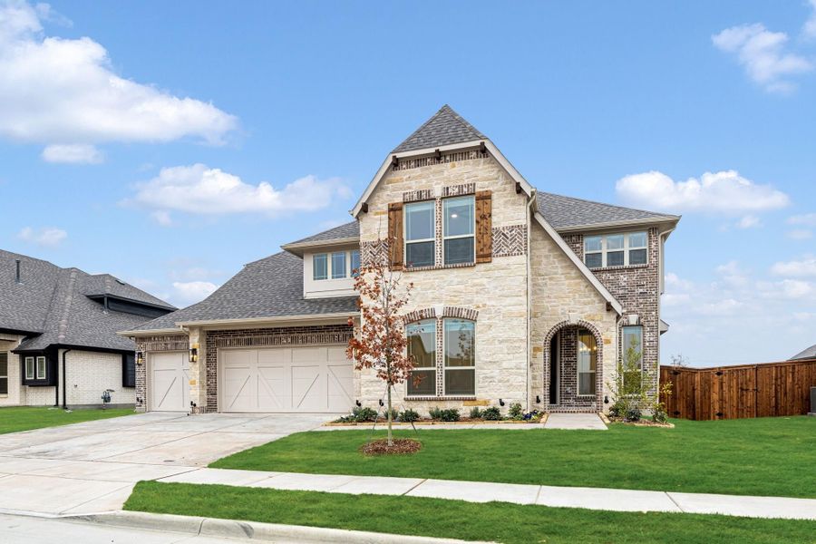 Two-story home with stone and brick exterior, two-car garage, arched entry, and wood shutters Two-story home with stone and brick exterior, two-car garage, arched entry, and wood shutters