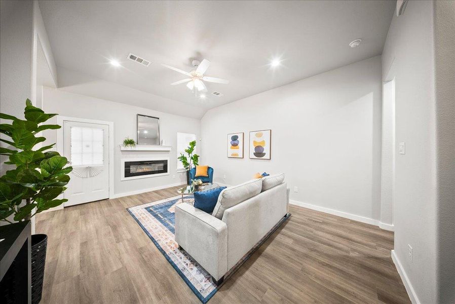 Living room with light wood-style flooring, a glass covered fireplace, ceiling fan, and recessed lighting Living room with light wood-style flooring, a glass covered fireplace, ceiling fan, and recessed lighting