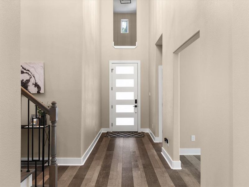 Foyer featuring dark wood-style flooring and a high ceiling