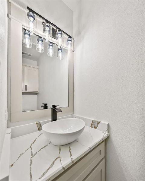 Bathroom with vanity and a textured wall