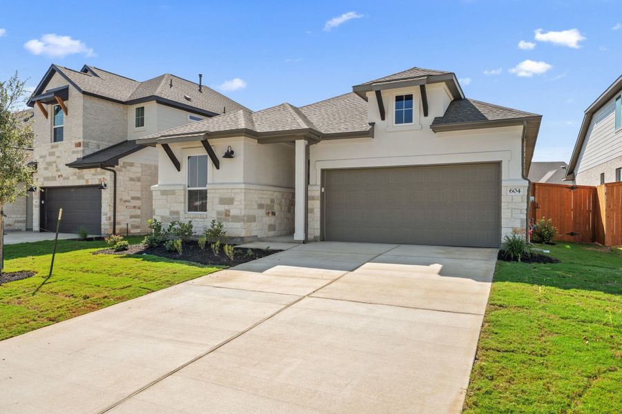 Front exterior of a new home in Lariat, Liberty Hill, TX, highlighting curb appeal (Image 22). Front exterior of a new home in Lariat, Liberty Hill, TX, highlighting curb appeal (Image 22).