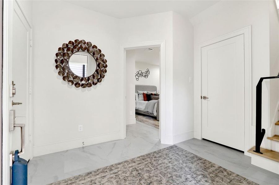 Specious foyer area leading into the en-suite bedroom on the first floor. The garage door is to your left side. On the right side, you have a specious coat closet and the stairs to the second floor.