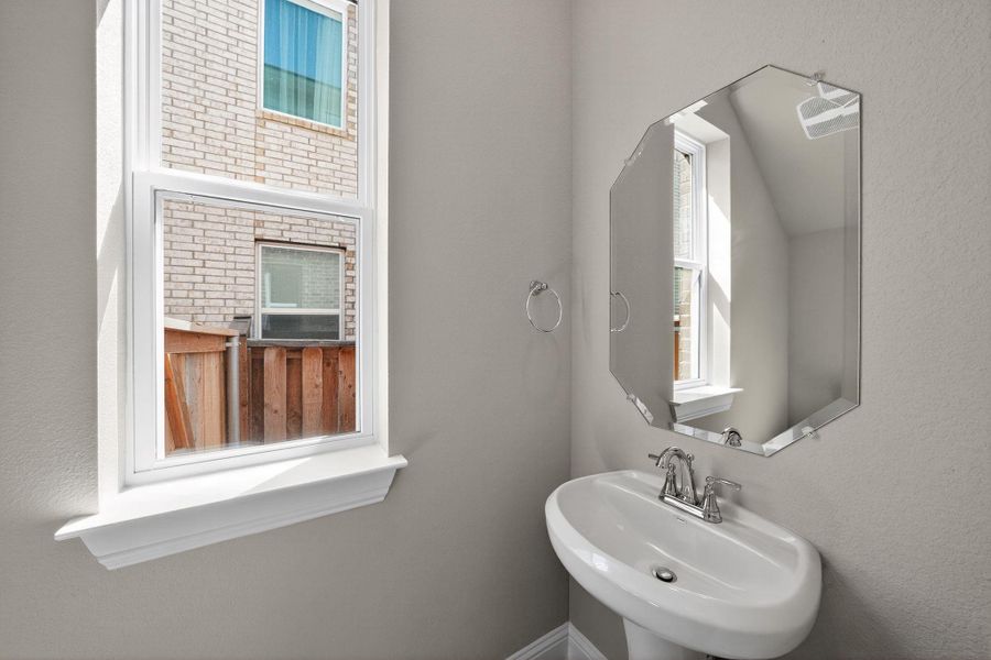 Bathroom featuring a sink and a textured wall Bathroom featuring a sink and a textured wall