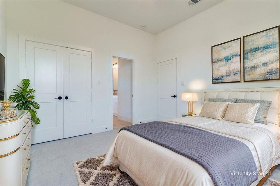 Bedroom with light carpet, a closet, and ensuite bathroom