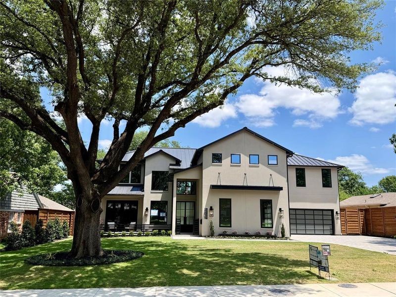 Contemporary two-story residence featuring a broad front lawn and a mature shade tree Contemporary two-story residence featuring a broad front lawn and a mature shade tree