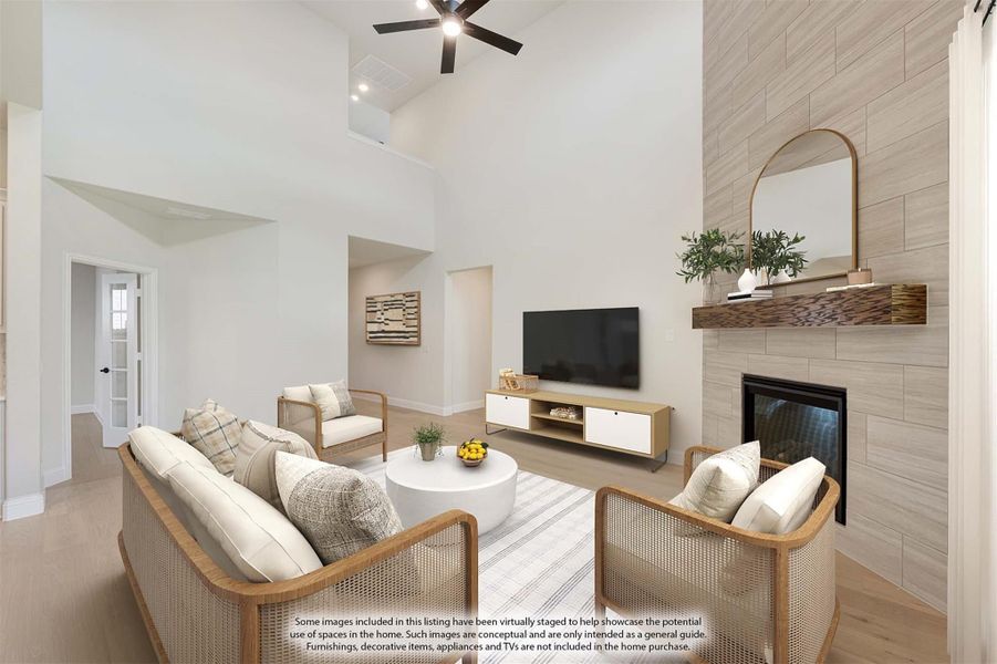 Living room with vaulted ceiling, tile fireplace, ceiling fan, and light wood floors Living room with vaulted ceiling, tile fireplace, ceiling fan, and light wood floors
