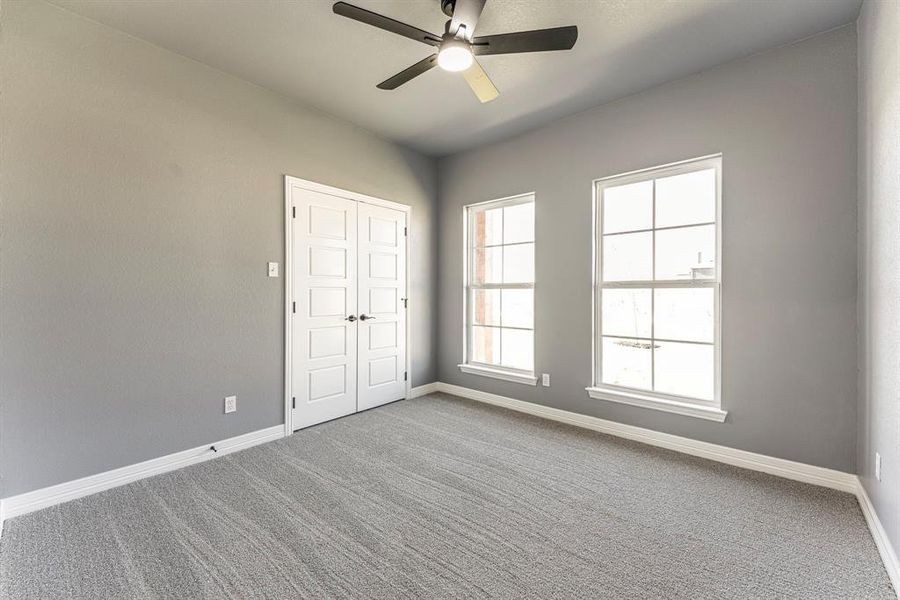 Spare room featuring carpet flooring and ceiling fan