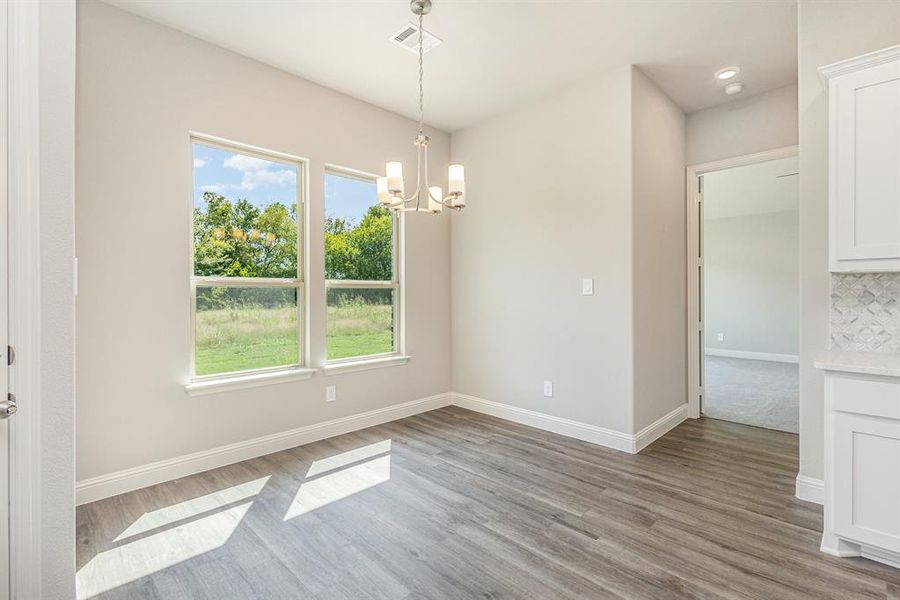 Unfurnished dining area with a chandelier and light wood finished floors Unfurnished dining area with a chandelier and light wood finished floors