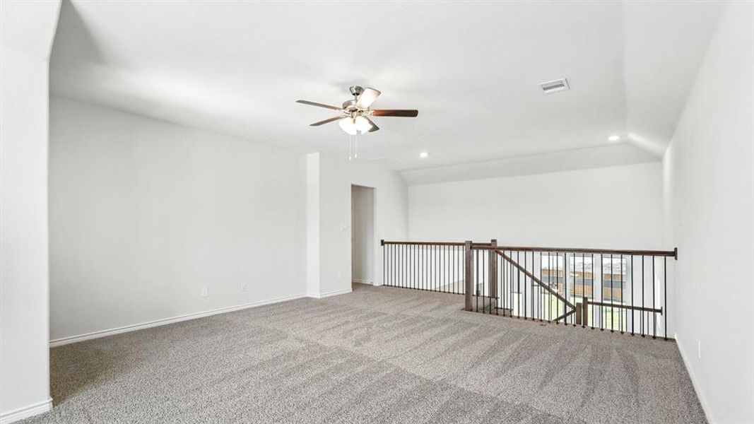 Spacious secondary living area featuring plush gray carpeting, a contemporary ceiling fan, and recessed lighting