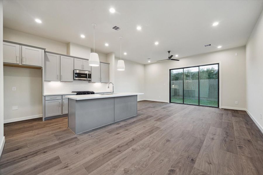 The open layout connects living, dining, and kitchen areas for effortless everyday living. Large sliding doors draw in natural light and create easy access to the backyard.