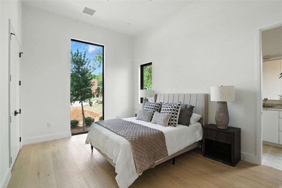 Bedroom with light wood-type flooring, access to outside, and ensuite bathroom Bedroom with light wood-type flooring, access to outside, and ensuite bathroom