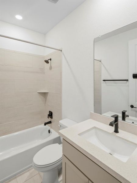 A well-appointed bath features a tiled shower, crisp white tub, and a vanity with sleek black fixtures. A well-appointed bath features a tiled shower, crisp white tub, and a vanity with sleek black fixtures.
