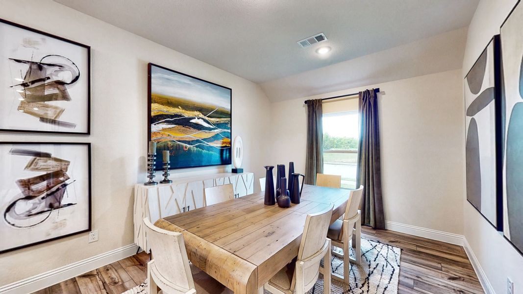 A dining room with a large painting on the wall. A dining room with a large painting on the wall.