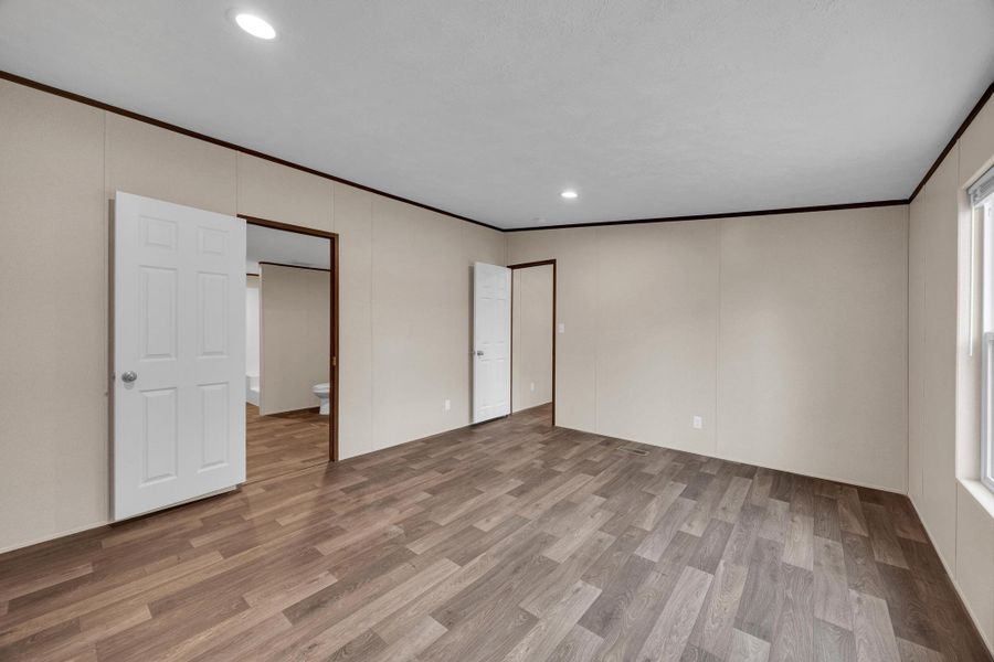 Unfurnished bedroom with light wood finished floors, ornamental molding, and recessed lighting