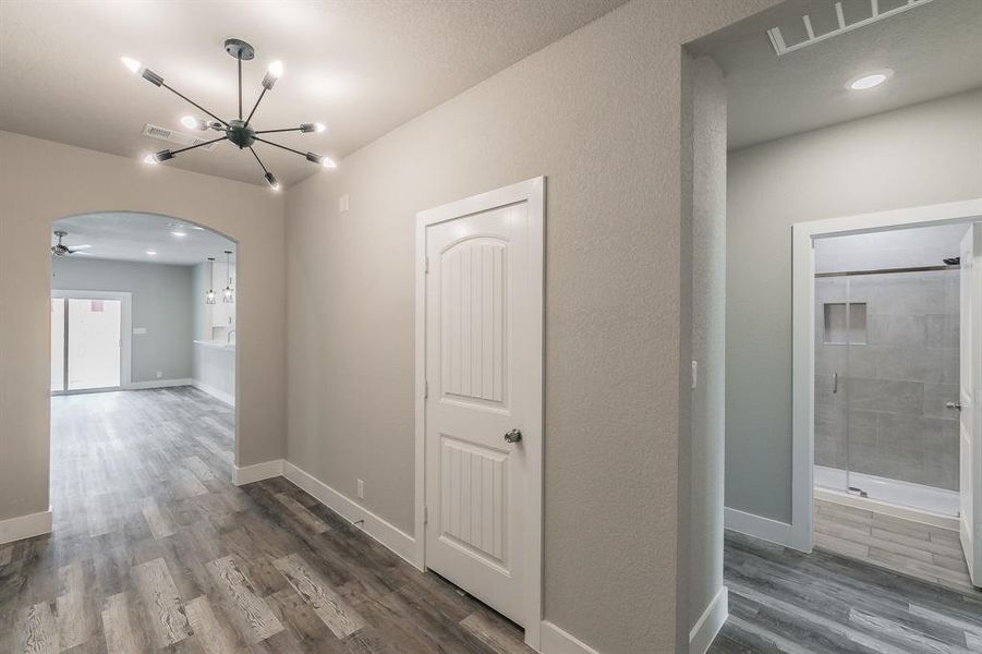 Hallway featuring a notable chandelier and dark hardwood / wood-style floors