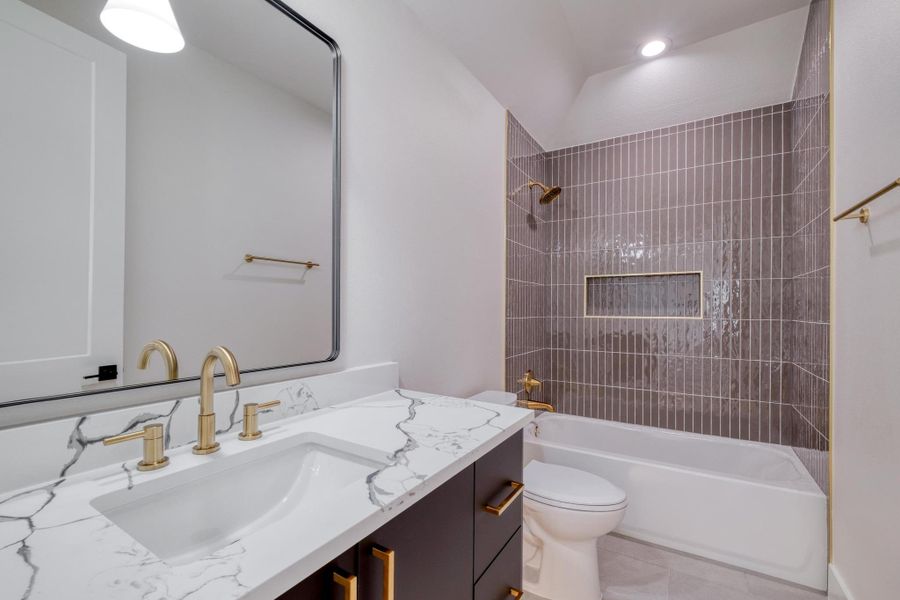 Full bathroom with tile patterned floors, shower / washtub combination, toilet, and vanity