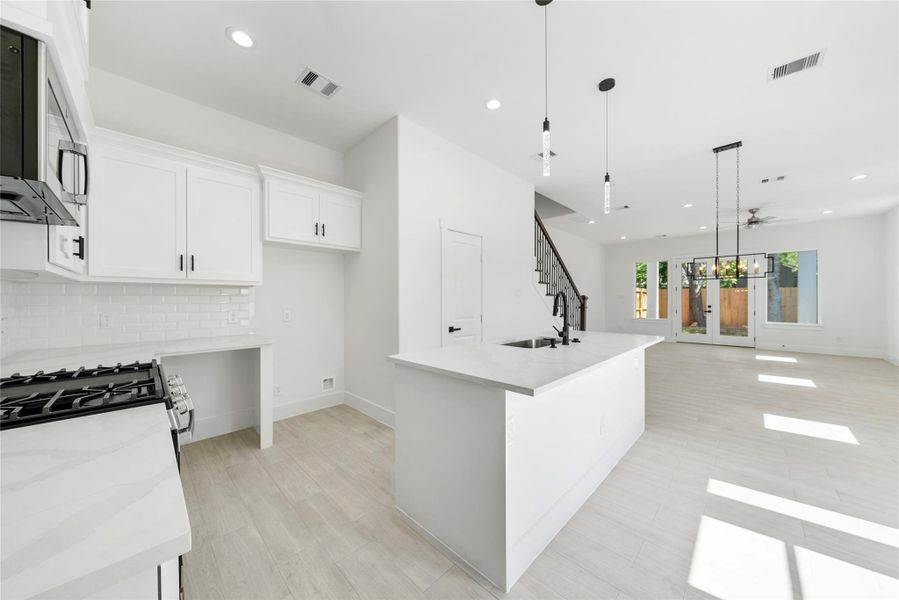 Stainless steel appliances, including the dishwasher, gas range, microwave vent hood, and wine fridge!