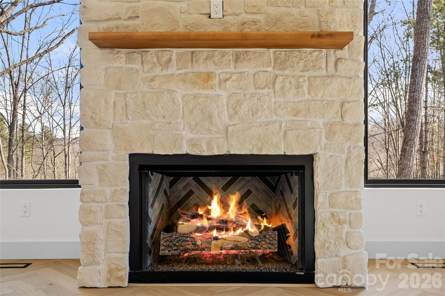 Custom gas fireplace with rough-cut casa blanca cultured stone surround with a white oak mantle