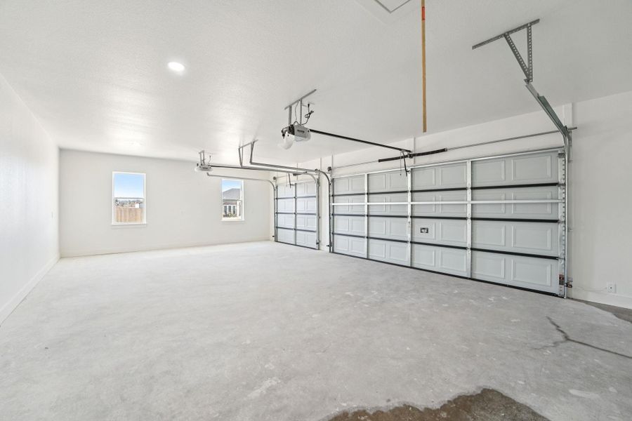Garage with recessed lighting and baseboards