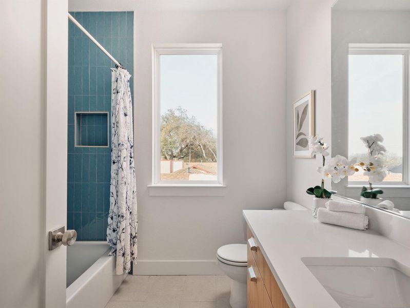 Bathroom with vanity, light tile patterned flooring, and shower / tub combo with curtain