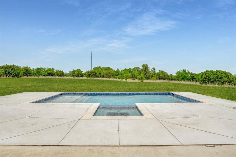Outdoor pool with a lawn and a patio area