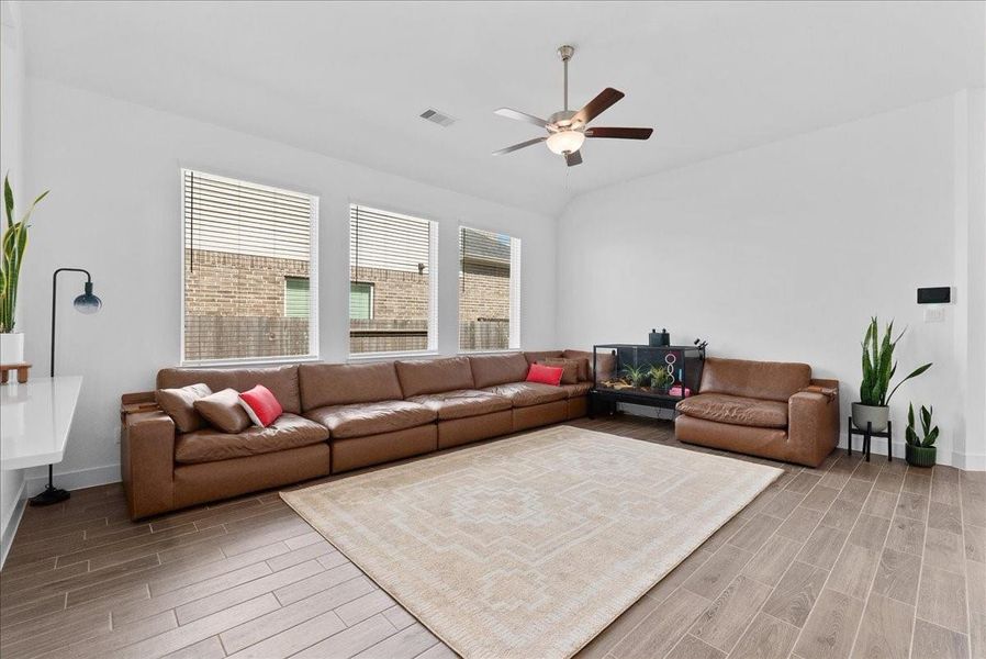 Three large windows fill the family room with natural light, highlighting the expansive layout and creating a bright, welcoming atmosphere. Three large windows fill the family room with natural light, highlighting the expansive layout and creating a bright, welcoming atmosphere.