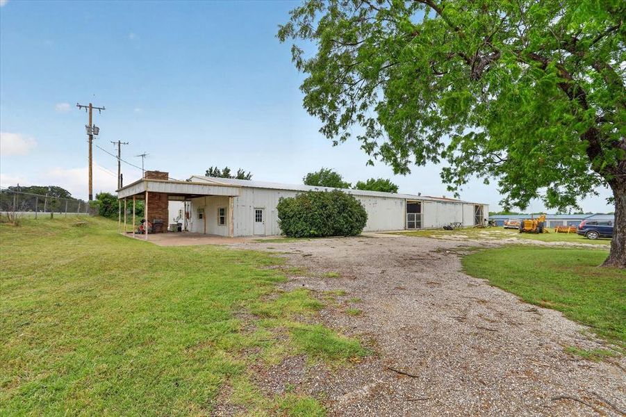 Expansive metal building with carport and multiple exterior doors