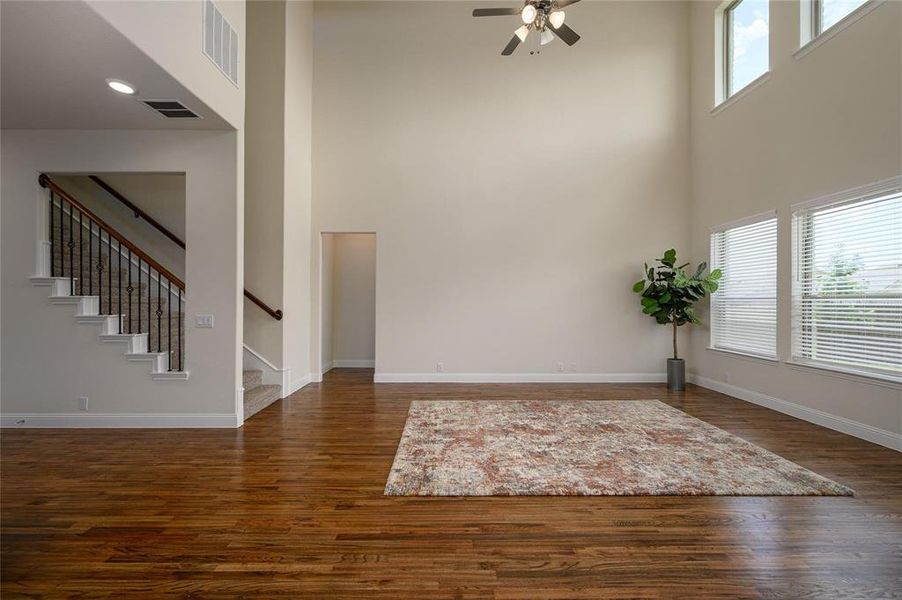 Entryway featuring ceiling fan, a towering ceiling, and dark wood-type flooring