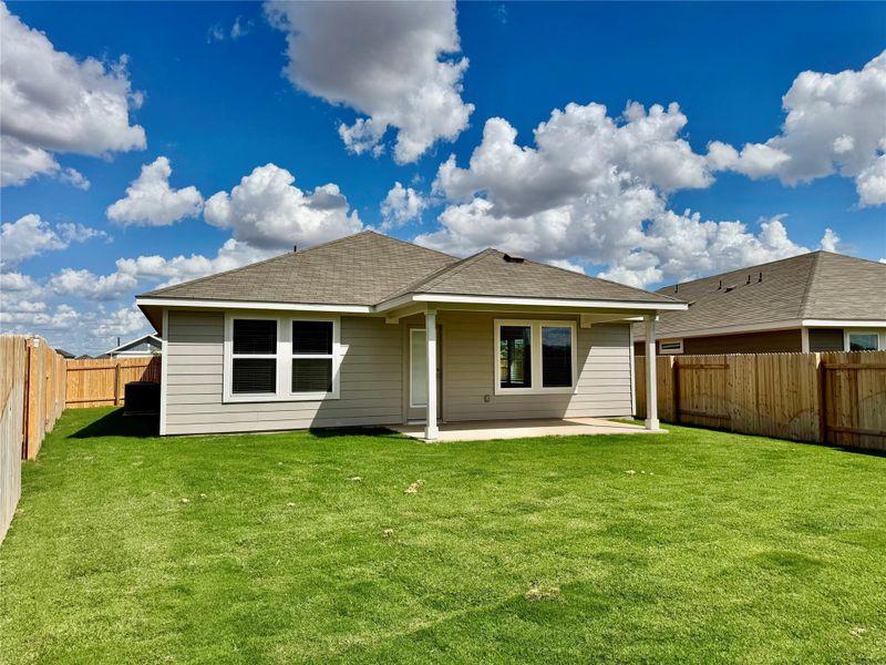 Rear view of house with a patio area, a fenced backyard, and roof with shingles