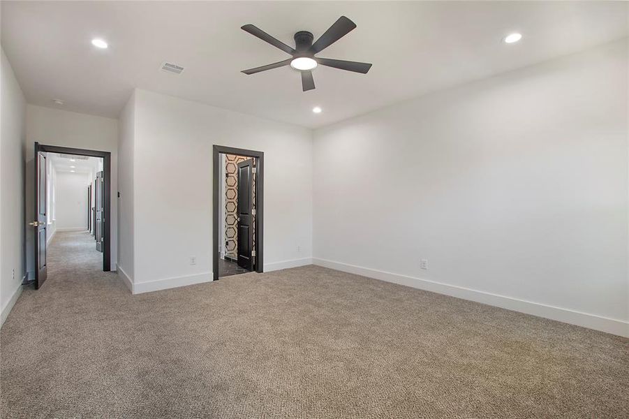 Unfurnished bedroom with a spacious closet, ceiling fan, carpet, and a closet