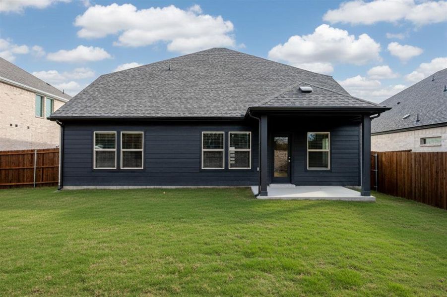 Rear view of property with a fenced backyard, a patio area, and a shingled roof Rear view of property with a fenced backyard, a patio area, and a shingled roof
