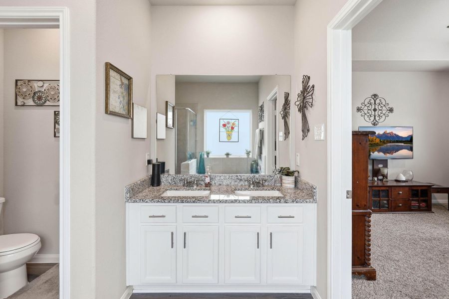 Primary bath has double sinks and granite countertops