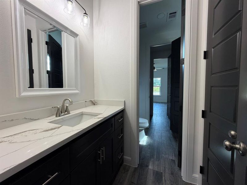 Bathroom vanity featuring a single basin, brushed nickel faucet, and a light-toned countertop with veining