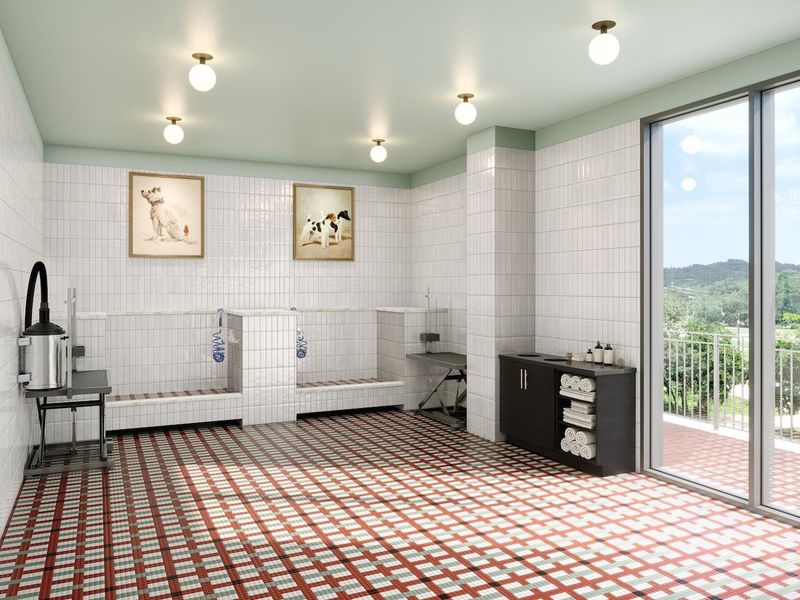 Pet spa with indoor wash and grooming stations, towel storage, and direct access to the outdoor pet area. Designed as a comfortable, social space where residents can enjoy time with their pets and friends.