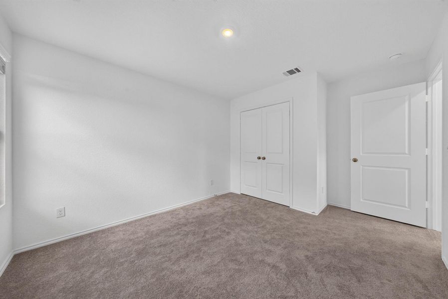 A well-lit, neutral-toned bedroom offers plush carpeting and ample closet space for comfortable living. A well-lit, neutral-toned bedroom offers plush carpeting and ample closet space for comfortable living.