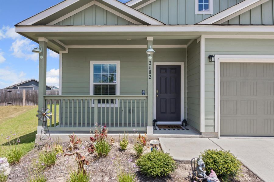 Entrance to property with covered porch, board and batten siding, and an attached garage Entrance to property with covered porch, board and batten siding, and an attached garage